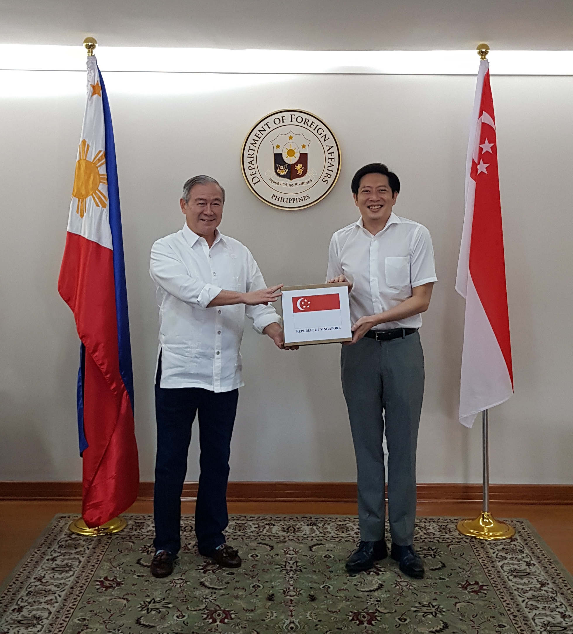 Singapore Ambassador to the Philippines Gerard Ho (right) handing over the COVID-19 diagnostic tests from Singapore to Philippine Secretary of Foreign Affairs Teodoro L Locsin Jr. (left).