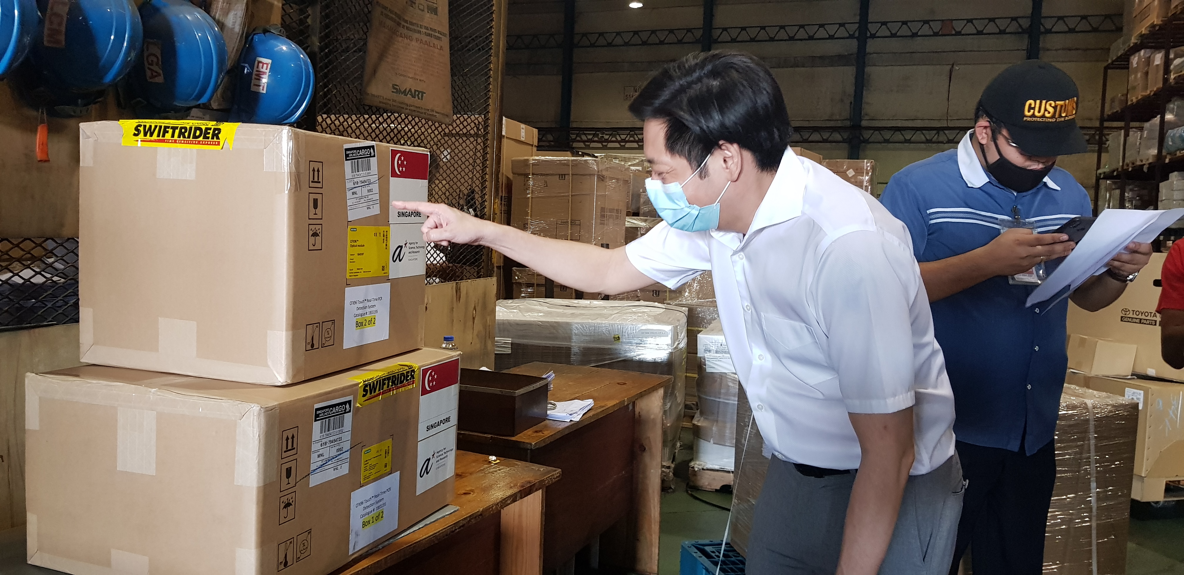 Singapore Ambassador to the Philippines Gerard Ho inspecting the shipment of COVID-19 diagnostic tests from Singapore at the Ninoy Aquino International Airport in Manila